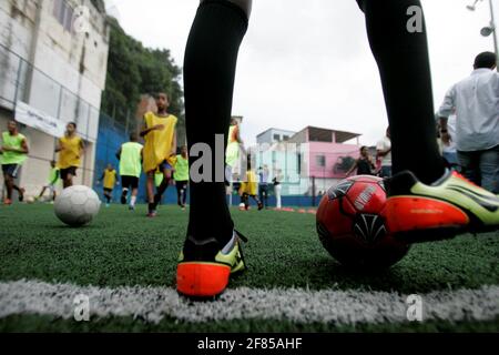 salvador, bahia / brésil - 24 juillet 2015: Des enfants sont vus pendant une formation dans une école de football sur un terrain de sport dans le quartier Candial dans le ci Banque D'Images