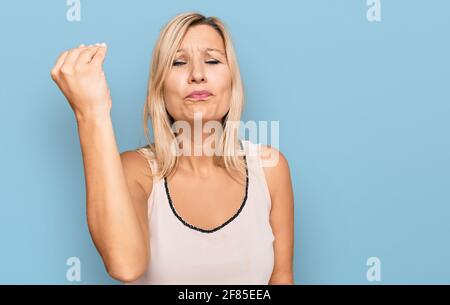 Femme de race blanche d'âge moyen portant des vêtements décontractés faisant un geste italien avec la main et les doigts d'expression confiante Banque D'Images