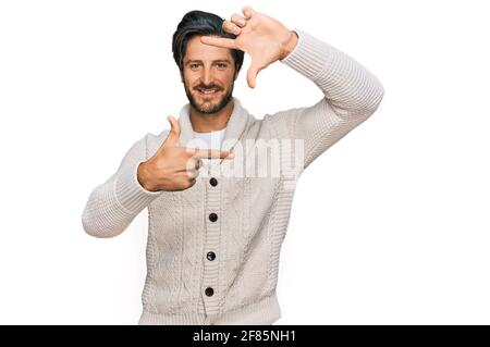 Jeune hispanique portant des vêtements décontractés souriant faisant cadre avec les mains et les doigts avec le visage heureux. Créativité et concept de photographie. Banque D'Images