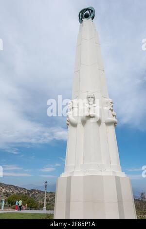 Gros plan de l'obélisque moderne de l'observatoire Griffith en avant-plan avec les touristes regardant la vue sur une belle journée au monument de Los Angeles. Banque D'Images