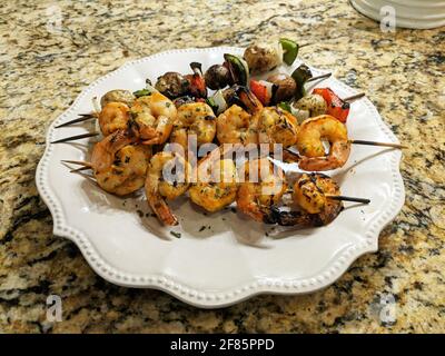 Crevettes grillées sur brochettes avec légumes sur l'assiette. Banque D'Images