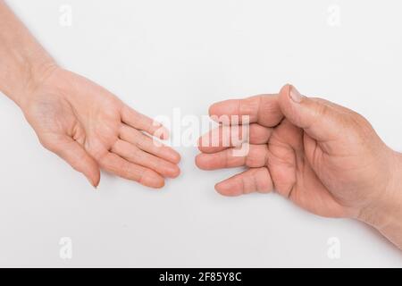 La main d'une femme âgée et d'un homme plus âgé sont attirés l'un vers l'autre sur fond blanc, isolés. Le concept d'aimer et de soutenir chacun Banque D'Images