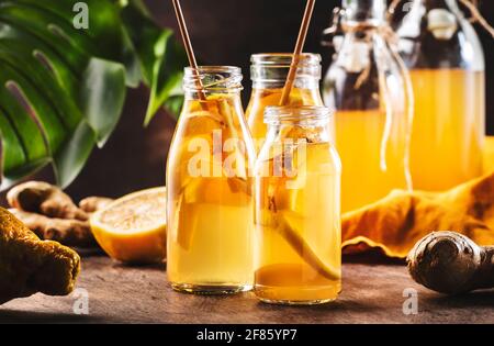 Boisson saine Kombucha fermentée avec gingembre brut et citron Bouteilles en verre. Thé prêt à boire Banque D'Images