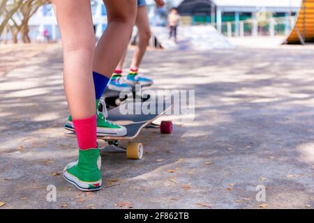 Gros plan asiatique fille surf skate ou planche à roulettes à l'extérieur le matin magnifique. Bonne jeune fille jouer surf skate au parc de rampe le matin. Gros plan Banque D'Images