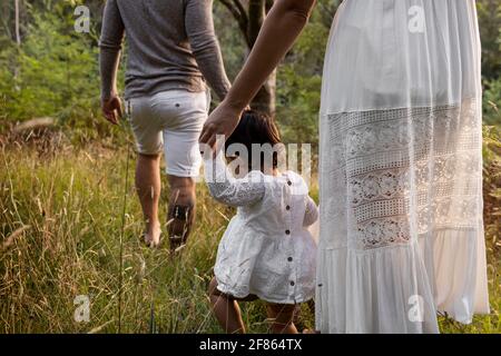 Jeune famille marchant dans les prairies forestières. Banque D'Images