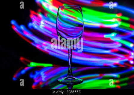 verre à vin sur fond de rayures colorées Banque D'Images