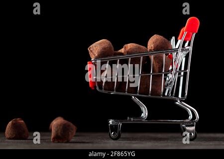 Image d'arrière-plan sombre avec un panier de jouets rempli de truffes au chocolat. Une image de concept pour faire du shopping pour noël, le jour de la Saint-Valentin où le choco Banque D'Images
