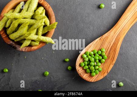 Gros plan image isolée d'un bol en bois rempli d'en-cas croquants de pois mange-tout verts, une alternative saine et nutritive aux frites. Vue de dessus a Banque D'Images