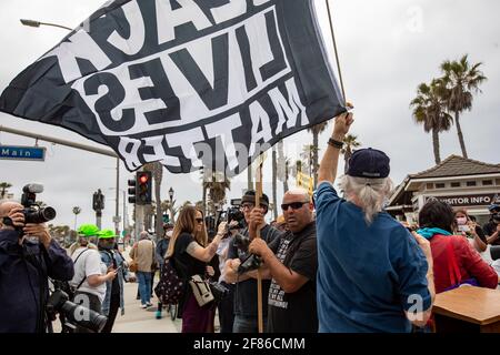 Los Angeles, Californie, États-Unis. 11 avril 2021. Dave Keeler, un habitant du comté d'Orange, fait passer un drapeau de la question des vies noires à la jetée de Huntington Beach, où quelques centaines de personnes se sont montrées pour protester contre un rassemblement prévu de White Lives Matter. Credit: Jill Connelly/ZUMA Wire/Alay Live News Banque D'Images