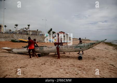 salvador, bahia, brésil - 18 décembre 2020: Les pêcheurs sont vus pousser un canoë dans la mer à côté de la colonie de pêcheurs sur la plage de Pituba, dans la ville o Banque D'Images