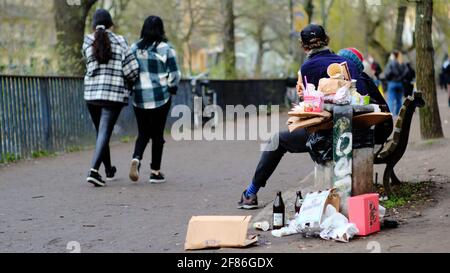 Berlin, Allemagne. 11 avril 2021. Les poubelles se trouvent à côté d'une poubelle débordante sur le Planufer dans le district de Kreuzberg, sur le côté de la route, à côté d'un banc où les gens sont assis. Credit: Stefan Jaitner/dpa/Alay Live News Banque D'Images