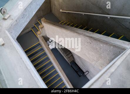 Un escalier menant à des chaises empilées dans le sous-sol Banque D'Images