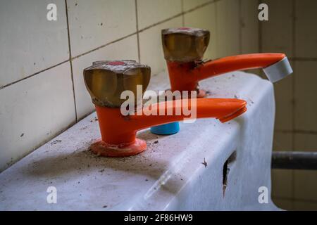 Gros plan d'un ancien robinet d'eau de la pastique dans un derélict maison Banque D'Images