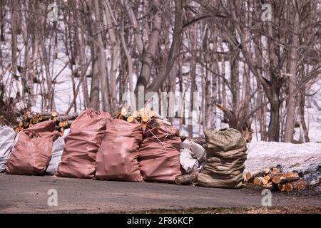 Une rangée de sacs roses remplis de bois de chauffage fraîchement haché Banque D'Images