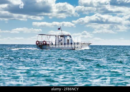 Bateau blanc rapide navigue par la mer. Jour d'automne ensoleillé. Vue latérale. Crimée, Sudak - 10 octobre 2020. Banque D'Images