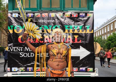 Black afro-caribbean participante au carnaval en costume de salsa, souriant au Notting Hill Carnival, Londres, Angleterre Banque D'Images