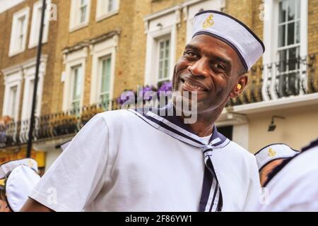 Un homme participant à la tenue du marin, souriant, au Notting Hill Carnival Parade Londres, Royaume-Uni Banque D'Images