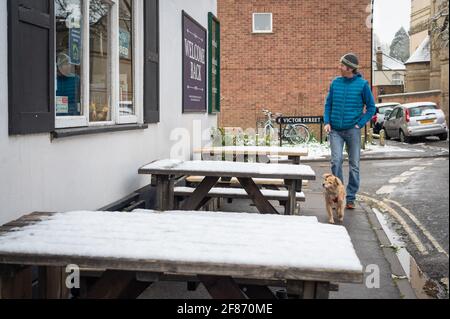 Oxford, Oxfordshire, Royaume-Uni. 12 avril 2021. Neige à Oxford. Le pays s'est réveillé à la neige dispersée, une surprise pour le temps d'avril. Stephen Charters prend son chien Roxie pour une promenade. Ils vérifient l'Old Booklicher Pub sur Canal St. pour voir si le service extérieur va redémarrer aujourd'hui alors que le pays émerge une étape de plus hors du verrouillage. Credit: Sidney Bruere/Alay Live News Banque D'Images