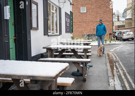 Oxford, Oxfordshire, Royaume-Uni. 12 avril 2021. Neige à Oxford. Le pays s'est réveillé à la neige dispersée, une surprise pour le temps d'avril. Stephen Charters prend son chien Roxie pour une promenade. Ils vérifient l'Old Booklicher Pub sur Canal St. pour voir si le service extérieur va redémarrer aujourd'hui alors que le pays émerge une étape de plus hors du verrouillage. Credit: Sidney Bruere/Alay Live News Banque D'Images