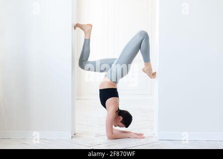 Beau jeune blogueur de forme physique faisant une poignée difficile dans la salle de lumière. Concept de formation régulière et volonté. Banque D'Images