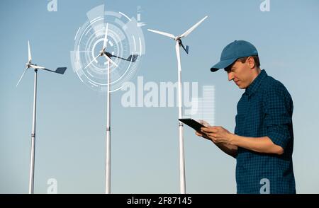 Ingénieur avec une tablette sur un fond d'éoliennes Banque D'Images