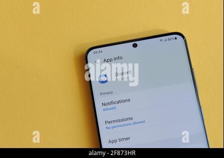 New york, États-Unis - 12 avril 2021 : modification des paramètres de confidentialité dans l'application Discord sur l'écran du smartphone sur fond jaune Banque D'Images