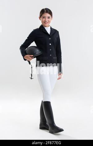 Bonne jeune femme en vêtements d'équitation Banque D'Images