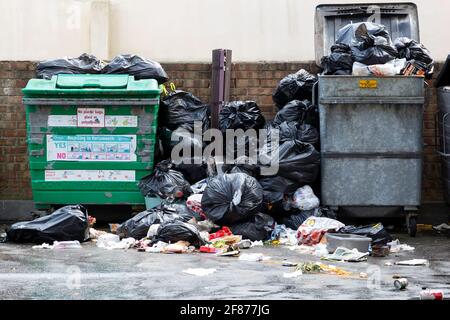 Poubelles ou poubelles débordant de sacs de déchets et de déchets avec des ordures ou des ordures partout dans la rue Banque D'Images