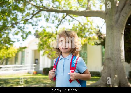 Enfant avec sacs à dos debout dans le parc près de l'école. Élèves avec des livres et des sacs à dos à l'extérieur. Concept d'éducation des enfants. Banque D'Images