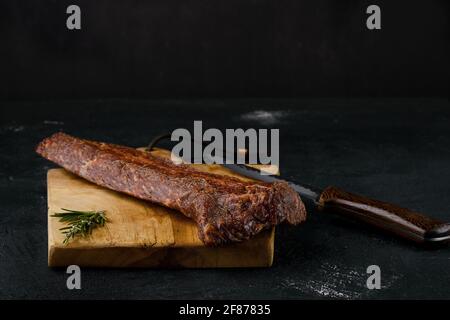 Viande de stripine de bœuf fumé sur la planche à découper Banque D'Images