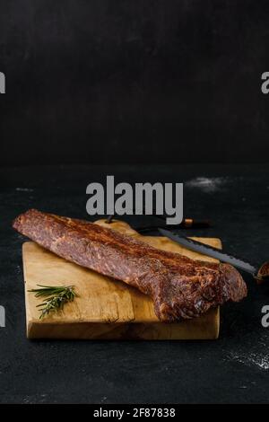 Viande de stripine de bœuf fumé sur la planche à découper Banque D'Images