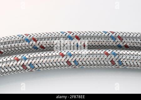 Tresse métallique en gros plan sur une chemise d'eau flexible sur un arrière-plan léger. Accessoires de plomberie. Banque D'Images