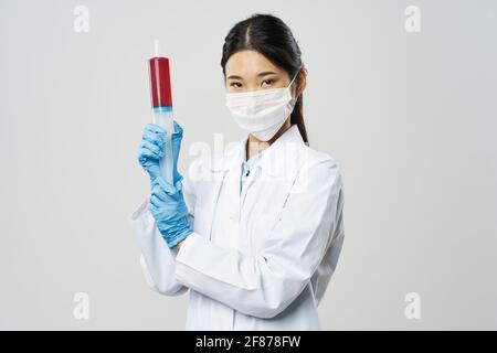 femme médecin avec seringue en main et gants bleus médecine coronavirus d'injection Banque D'Images