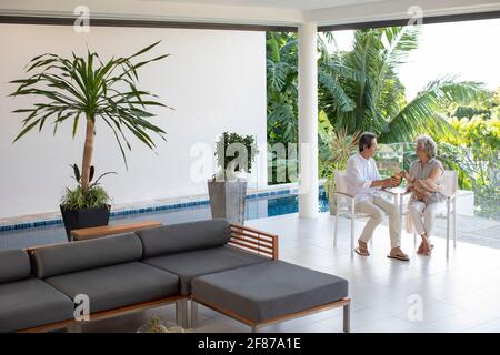 Bon couple senior qui boit du lait de coco dans la villa de vacances Banque D'Images