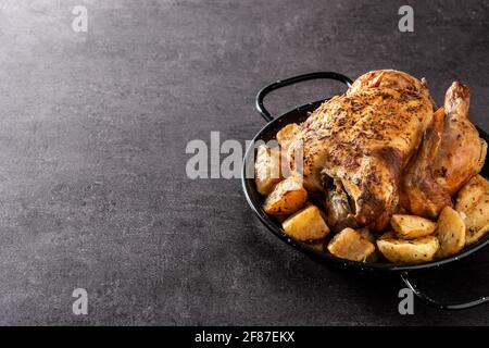 Poulet rôti maison avec pommes de terre sur fond noir Banque D'Images