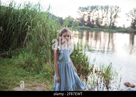Une fille se tient sur la rive du lac à proximité nutria dans l'eau Banque D'Images