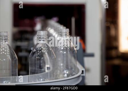 Bouteille en plastique transparent sur la machine factory line dans la fabrication de boissons, selective focus. Banque D'Images