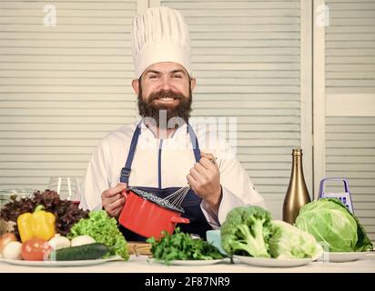 Conseils et astuces pour fouetter de la crème. Utiliser un fouet manuel. Un chef professionnel tient le fouet et le bol. Fouetter comme un pro. Homme barbu gars dans le tablier fouetter des oeufs ou Banque D'Images