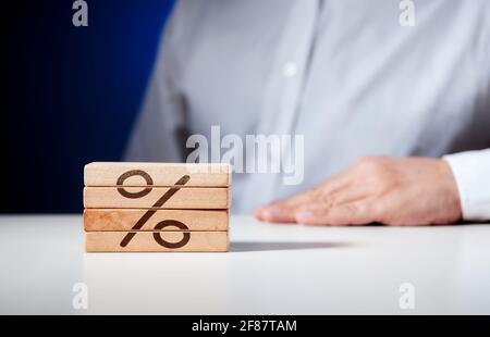 Panneau pour cent sculpté sur des blocs de bois avec un homme d'affaires assis dans l'arrière-plan. Concept d'entreprise. Banque D'Images