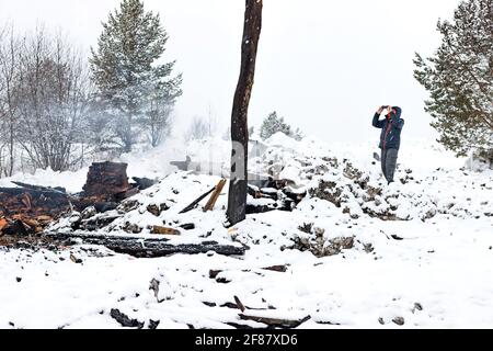 Hommes faisant la photo de restes de conflagration maison brûlée Banque D'Images