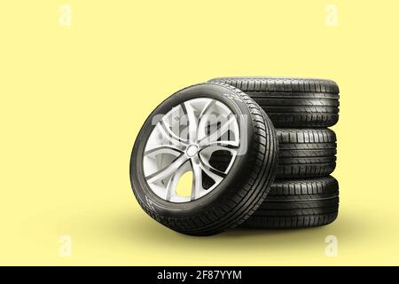 pneus et roues d'été – empiler sur fond jaune, nouvelles roues. Banque D'Images