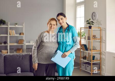 Portrait d'un médecin heureux avec sa patiente senior debout ensemble et regarder l'appareil photo Banque D'Images