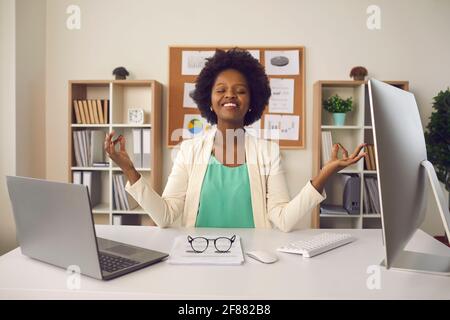 Jeune femme assise au bureau et méditant uniquement la concentration sur les émotions positives Banque D'Images