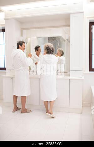 Un couple de personnes âgées heureux se brossant les dents dans la salle de bains Banque D'Images