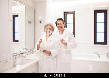 Un couple de personnes âgées heureux se brossant les dents dans la salle de bains Banque D'Images