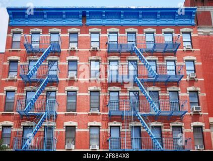 Vieux bâtiment en brique rouge avec des évasions de feu de fer bleu, New York City, États-Unis. Banque D'Images