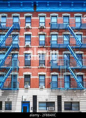 Vieux bâtiment en brique rouge avec des évasions de feu de fer bleu, New York City, États-Unis. Banque D'Images