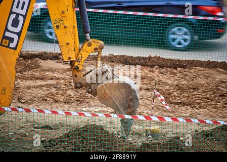 Le godet de la chargeuse-pelleteuse JCB creuse le sol Banque D'Images