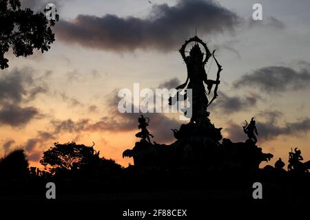 Silhouette de la statue contre le coucher du soleil à Bali, Indonésie Banque D'Images