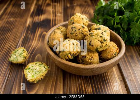 Falafel de pois chiches dans le bol brun sur fond de bois Banque D'Images